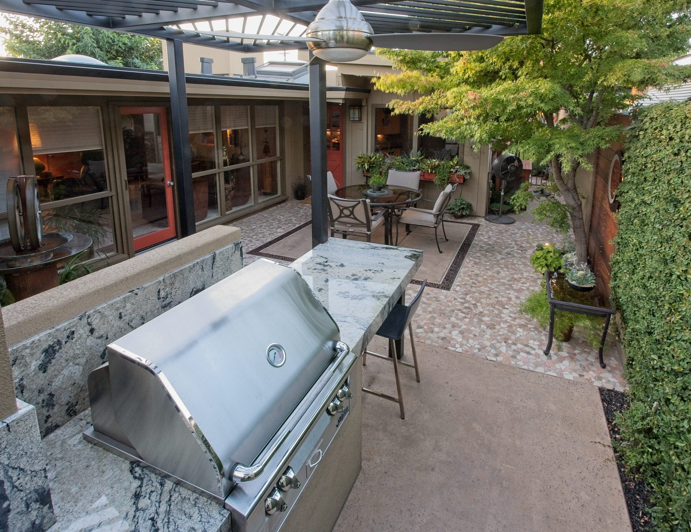 An intimate patio with controlled access for a mid-century modern home. Decorative drain grating and rich patterns enliven the space.